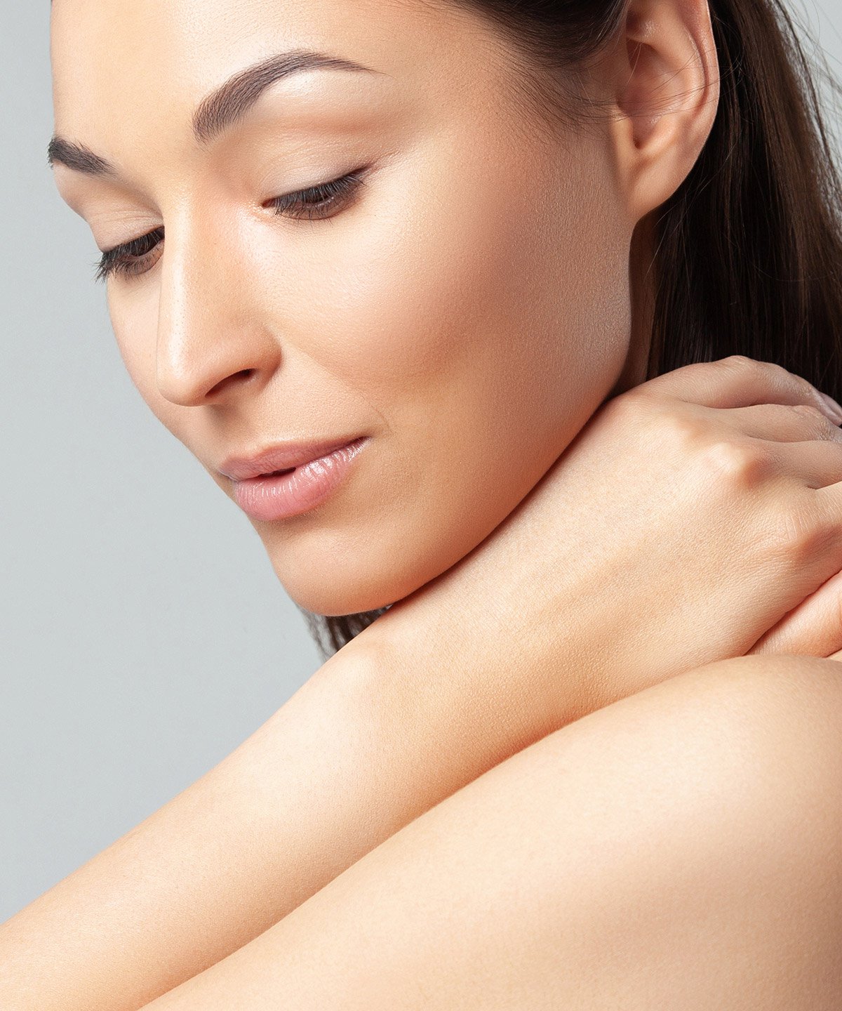 Female microneedling patient resting head on her arm